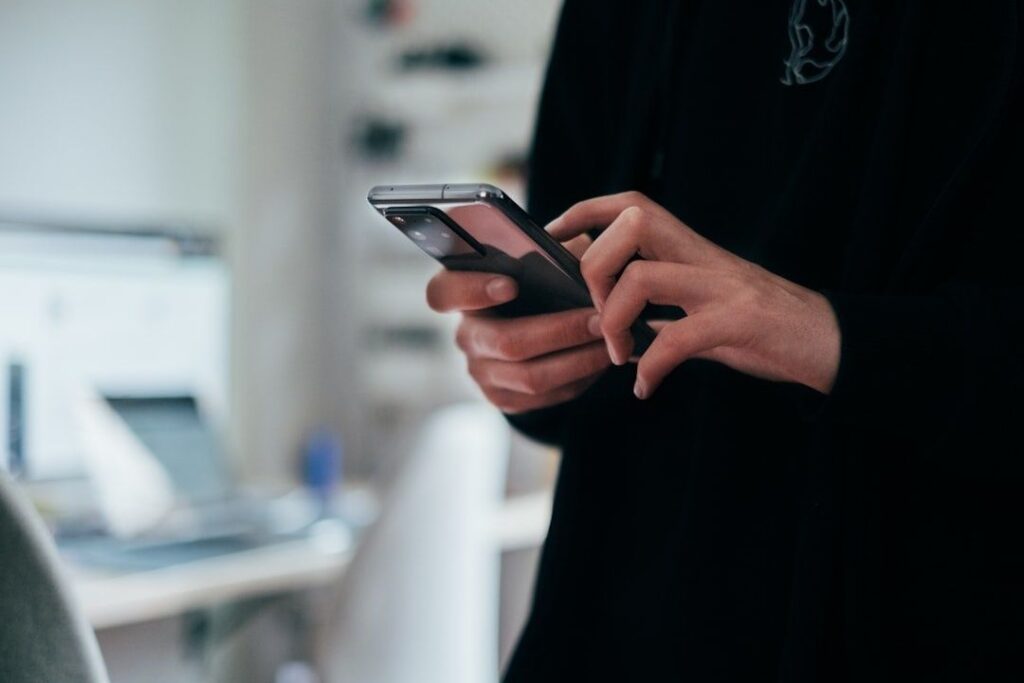 Person håller en smartphone och läser eller granskar information i mobilen